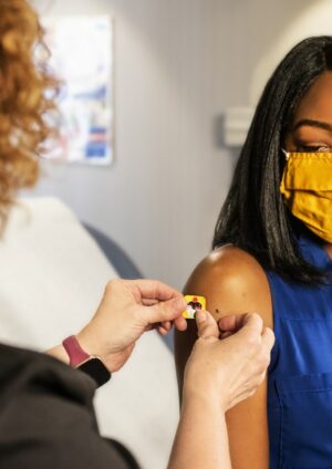 Une jeune fille afro-américaine se faisant vacciner dans une clinique.