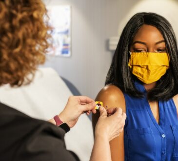 Une jeune fille afro-américaine se faisant vacciner dans une clinique.