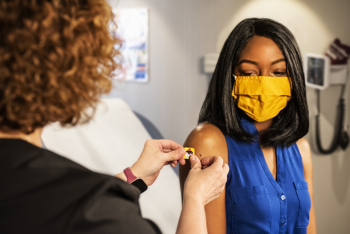 Une jeune fille afro-américaine se faisant vacciner dans une clinique.