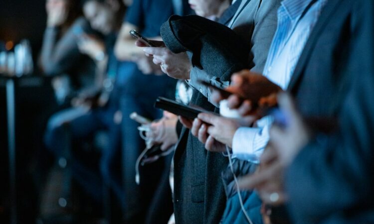 Des personnes avec un smartphone dans un métro.