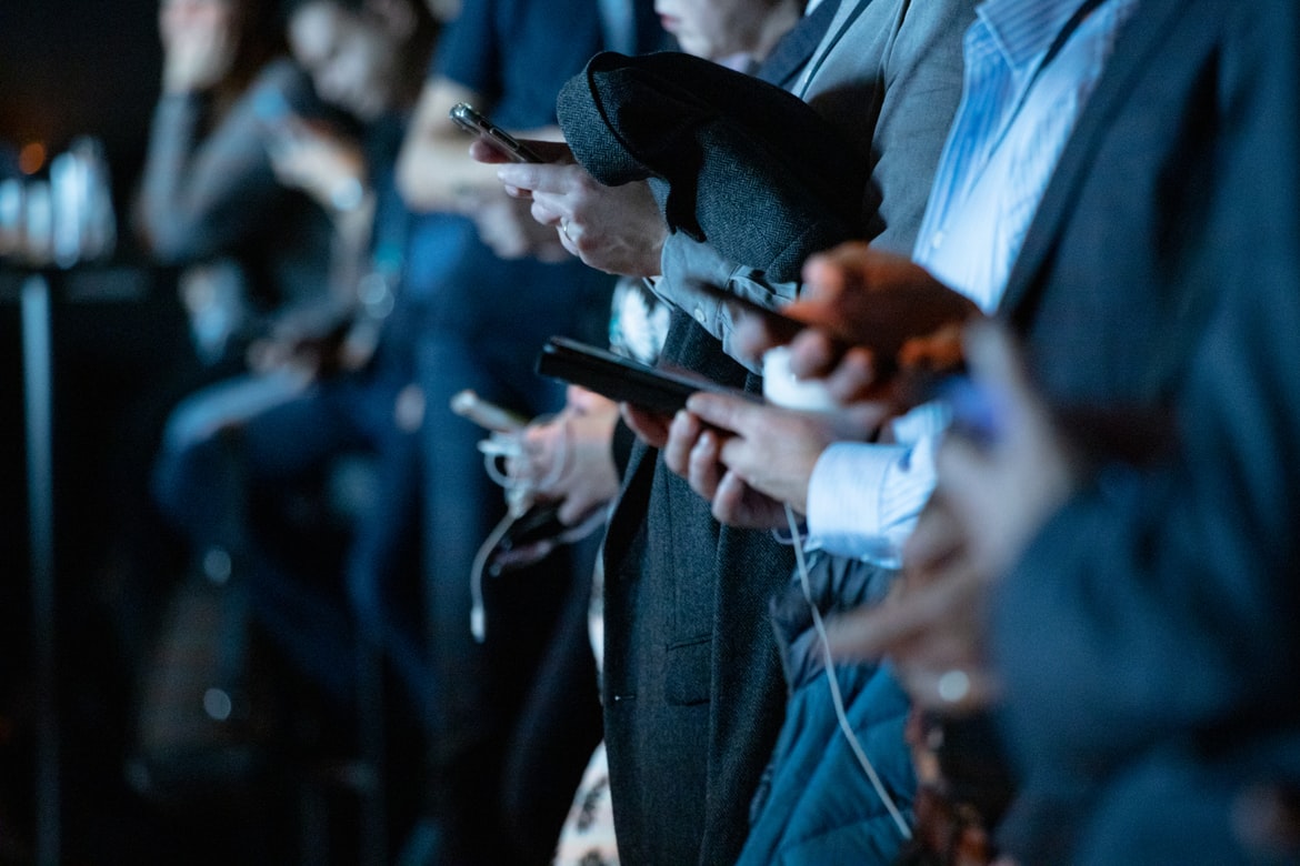 Des personnes avec un smartphone dans un métro.